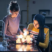 Two kids examine a light bulb experiment