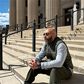 Ralph Crowder sits on the steps outside Northrop