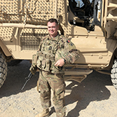 Charles Christianson in front of an armored vehicle