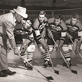 John Mariucci with players in black and white photo