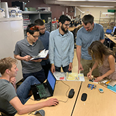 students and faculty converse around a table