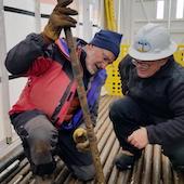 two researchers examine an ice core