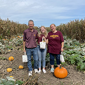 Two parents and daughter in pumpkin patch