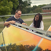 two people examine solar panel installation