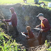 students taking soil samples from pit