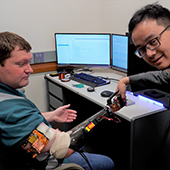 Zhi Yang shakes hands with research participant Cameron Slavens