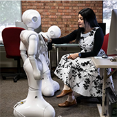 Arshia Khan and two robots interact