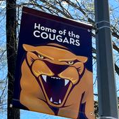 Campus banner reading Home of the Cougars with pic of cougar mascot