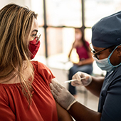 Nurse giving a woman a vaccine shot