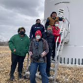 Intercultural Sustainability Leaders program team leaders post at base of wind tower