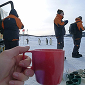 Neff and crew enjoy coffee with penguins in background