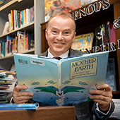 Marek Oziewica reading a book called Mother Earth