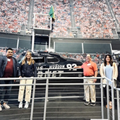 Students and faculty with stadium backdrop