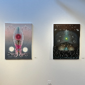 Two artworks from the Biophilia exhibit hang on a wall