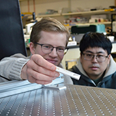 Two students observe an experiment with metamaterial object