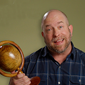 Ryan Bergstrom holding a wooden globe