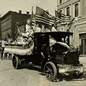an old black and white photo of a truck in a parade