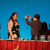 A student receives a medal on a podium