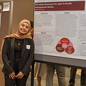 Ruqayah Ali standing by her research poster