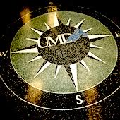 a large inlaid stone compass on a floor reading UMD