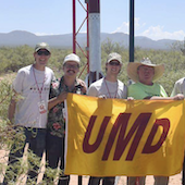UMD rocket team holding a banner reading UMD