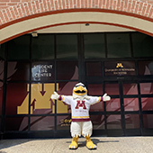 a raptor mascot stands in front of a new building