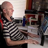 Philip O’Keefe, an Australian implant recipient, sits at a computer