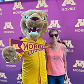 Woman taking photo with Pounce the mascot