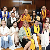 A group of people including the Dali Lama pose for a photo