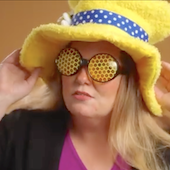 Jodie Reik in a large yellow joke top hat and sunglasses