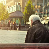 an older man on a park bench alone