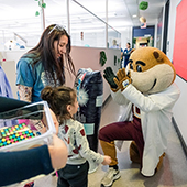 Goldy Gopher interacts with a child at a dentistry appointment