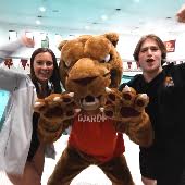 two students celebrate with a cougar mascot
