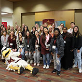 UMR students and families post for a photo with Rocky Raptor mascot