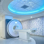 An MRI machine with colorful lighting and artwork around it