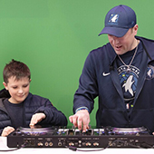 A dj shows a child how to use his dj station