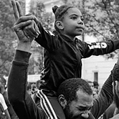 a young black girl on her father's shoulders