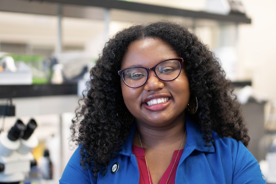 Angeline Dukes in a lab smiling at the camera.