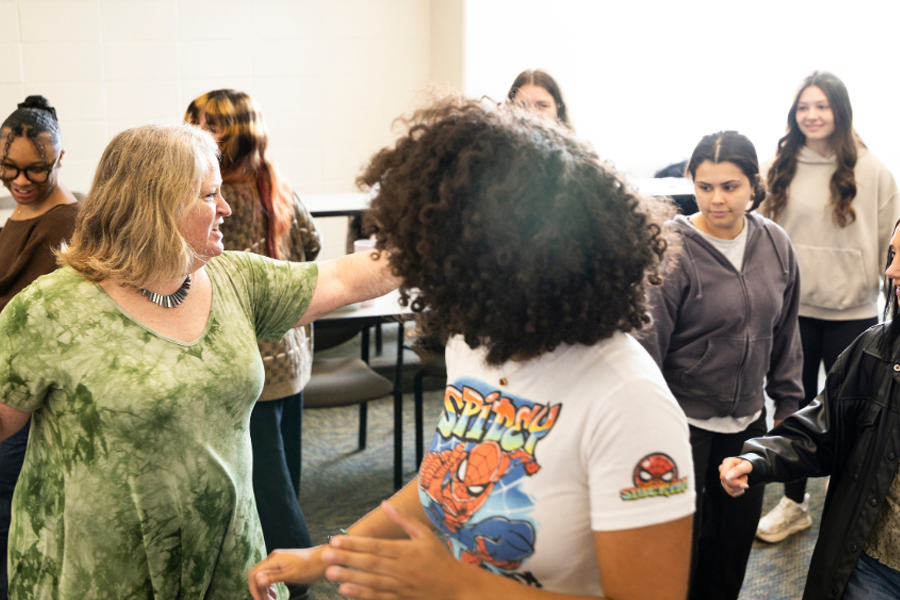 People moving in a classroom while looking away from the camera.