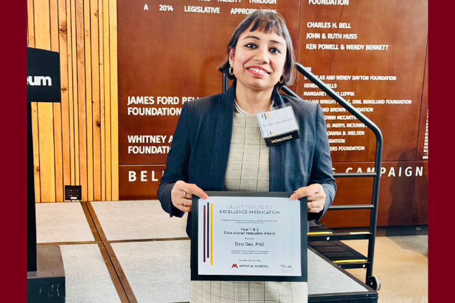 Devaleena Das smiles at the camera while holding a certificate.