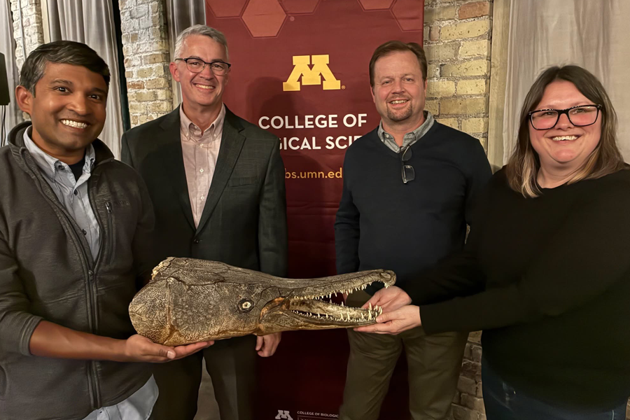 Solomon David, Kieran McNulty, Pete Makovicky and Trinity Hamilton pose for a group photo holding a fossilized gar head.