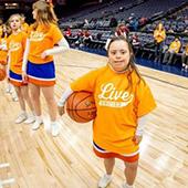 a young girl who is a special olympics athlete on a basketball court