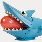 toy shark with water balloon in teeth