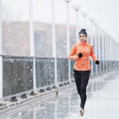 woman running in snow over washington ave bridge